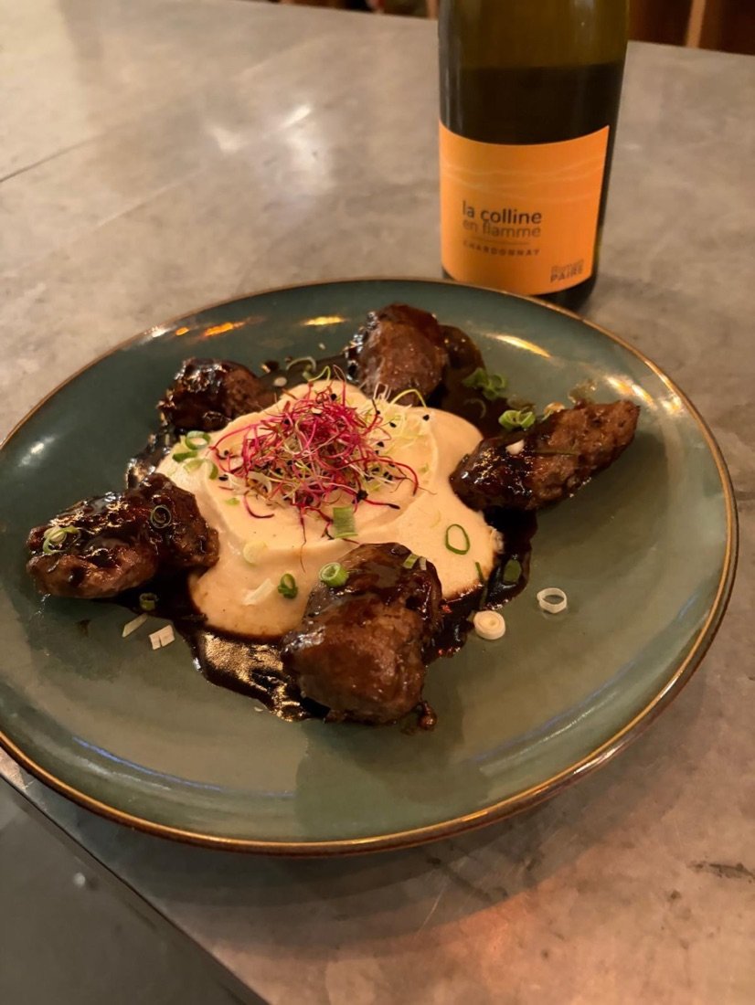 Boulettes de viande, purée et jus corsé, avec une bouteille de la Colline en flamme